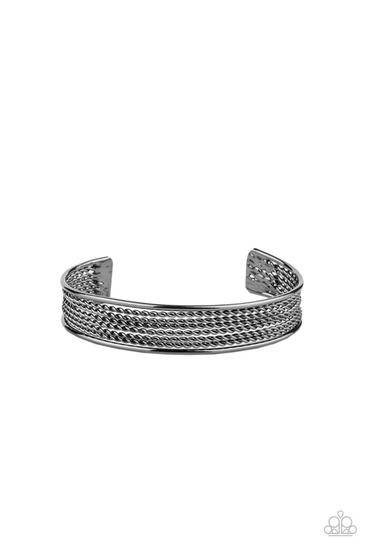 Sections of twisted gunmetal wires are bordered by two smooth gunmetal bars, coalescing into a bold industrial cuff around the wrist.