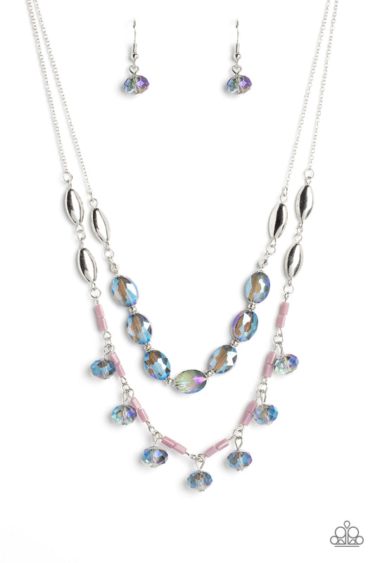 Two strands of dainty silver chain are adorned in a collection of mauve opaque beads, faceted glassy blue beads, and silver accents, culminating in a layered design rich with vintage character