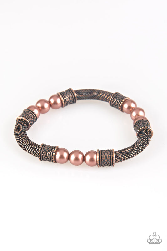 Pearly copper beads, ornate copper accents, and sections of copper mesh chain are threaded along a stretchy band around the wrist for a refined flair.