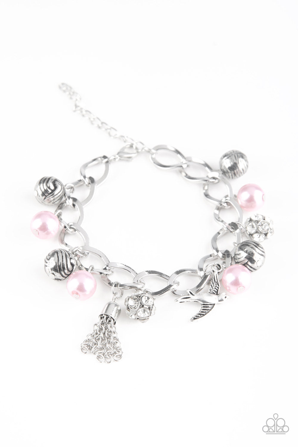 Pink pearls, ornate silver beads, and white rhinestone encrusted accents swing from a dramatic silver chain. A shimmery silver bird charm and silver tassel are added to the display, creating a whimsical fringe around the wrist. Features an adjustable clasp closure.