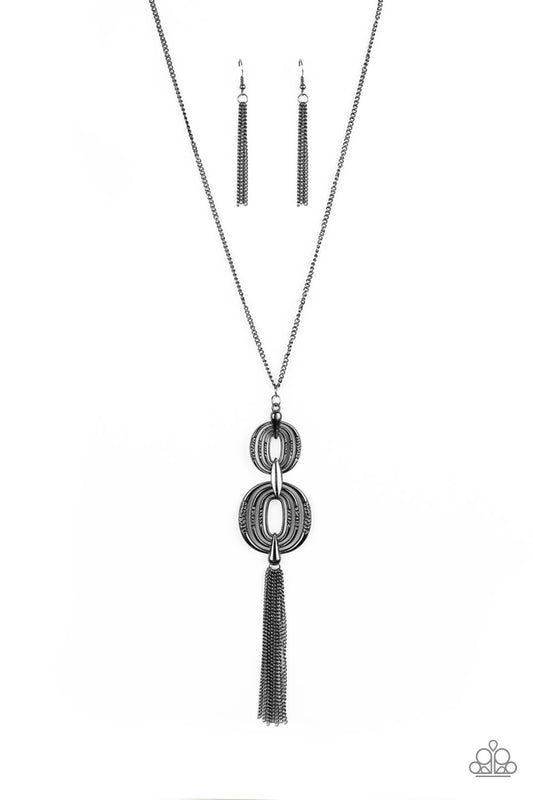 Delicately hammered in sections of shimmer, gunmetal circular frames stack into a bold pendant at the bottom of a lengthened gunmetal chain. A shimmery gunmetal tassel swings from the bottom of the stacked pendant for a casual finish. Features an adjustable clasp closure.