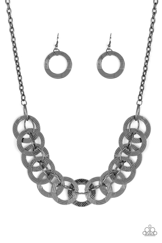 Etched and hammered in linear and diamond-cut shimmer, glistening gunmetal circles interlock into a bold industrial chain below the collar. Features an adjustable clasp closure.