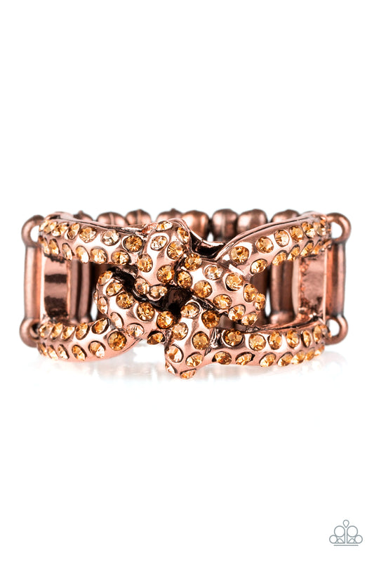 Encrusted in glittery rhinestones, shimmery copper bars crisscross across the finger, coalescing into a bold square knot atop the finger. Features a stretchy band for a flexible fit.