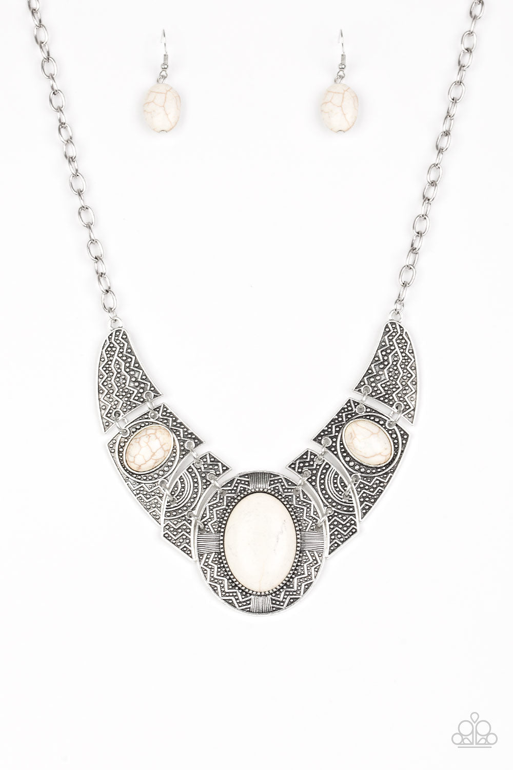 Radiating with studded and tribal inspired patterns, antiqued silver plates connect below the collar for a fierce look. Refreshing white stones are pressed into the plates, adding an artisan flair to the dramatic centerpiece. Features an adjustable clasp closure.