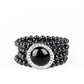 Threaded along stretchy bands, row after row of black beads are held in place by an exaggerated black beaded frame encrusted in glassy white rhinestones for a refined finish.