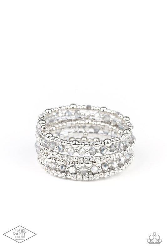 An icy collection of silver beads, silver cubes, metallic crystals, and glassy white rhinestones are threaded along a coiled wire, creating a blinding infinity wrap style bracelet around the wrist.