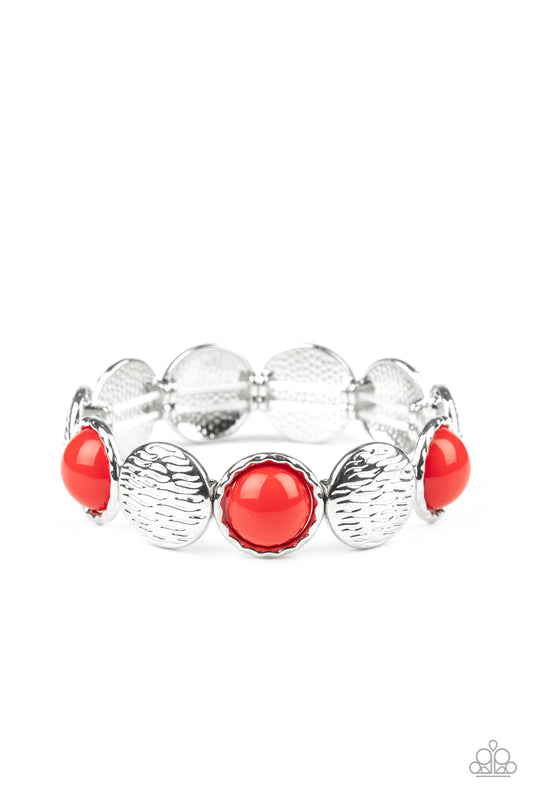 Embossed in wavy textures, shiny silver discs and bubbly red beaded frames are threaded along a stretchy band around the wrist, creating a colorful statement piece.