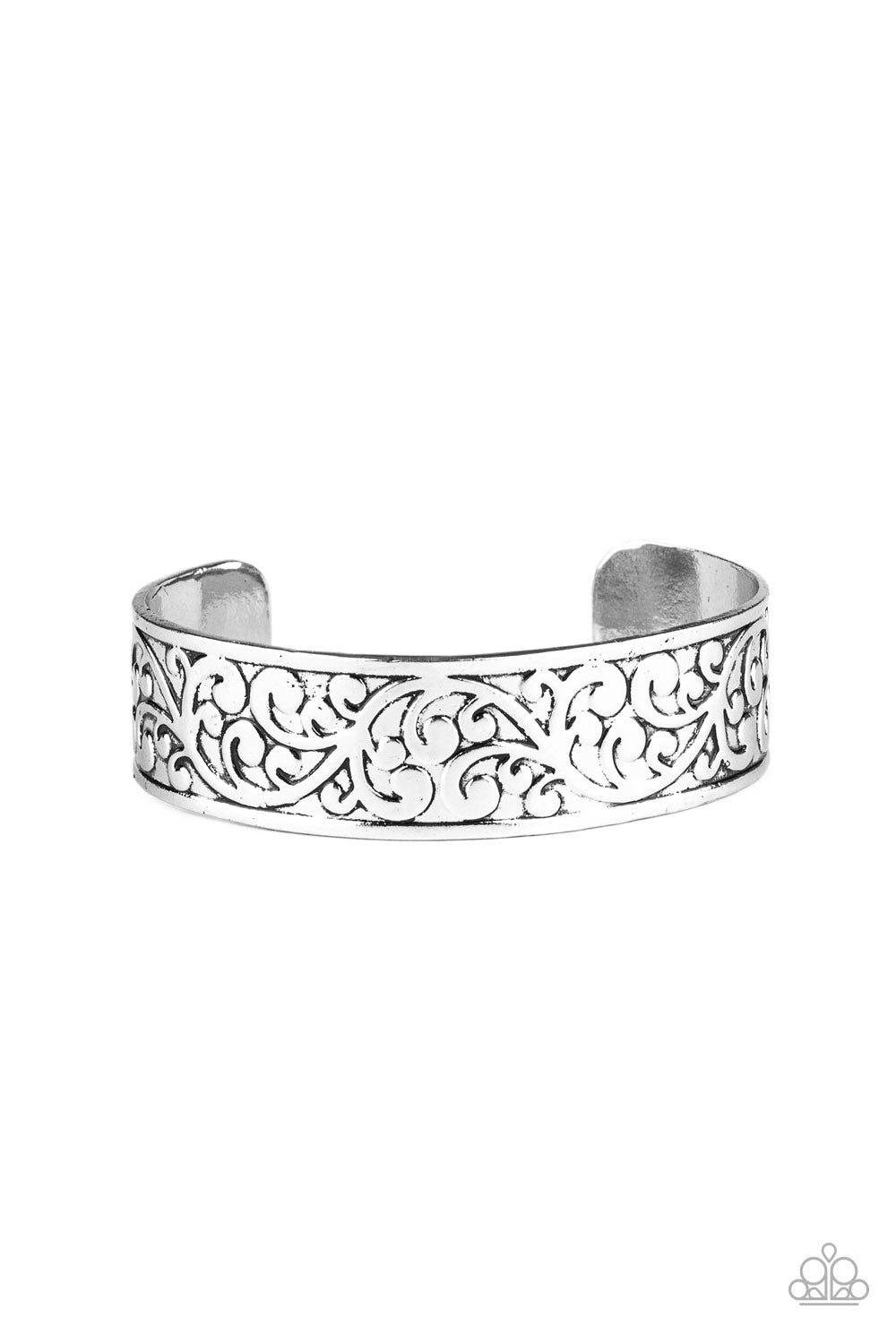 Brushed in an antiqued shimmer, vine-like filigree is embossed across the front of the a thick silver cuff for a whimsical look.