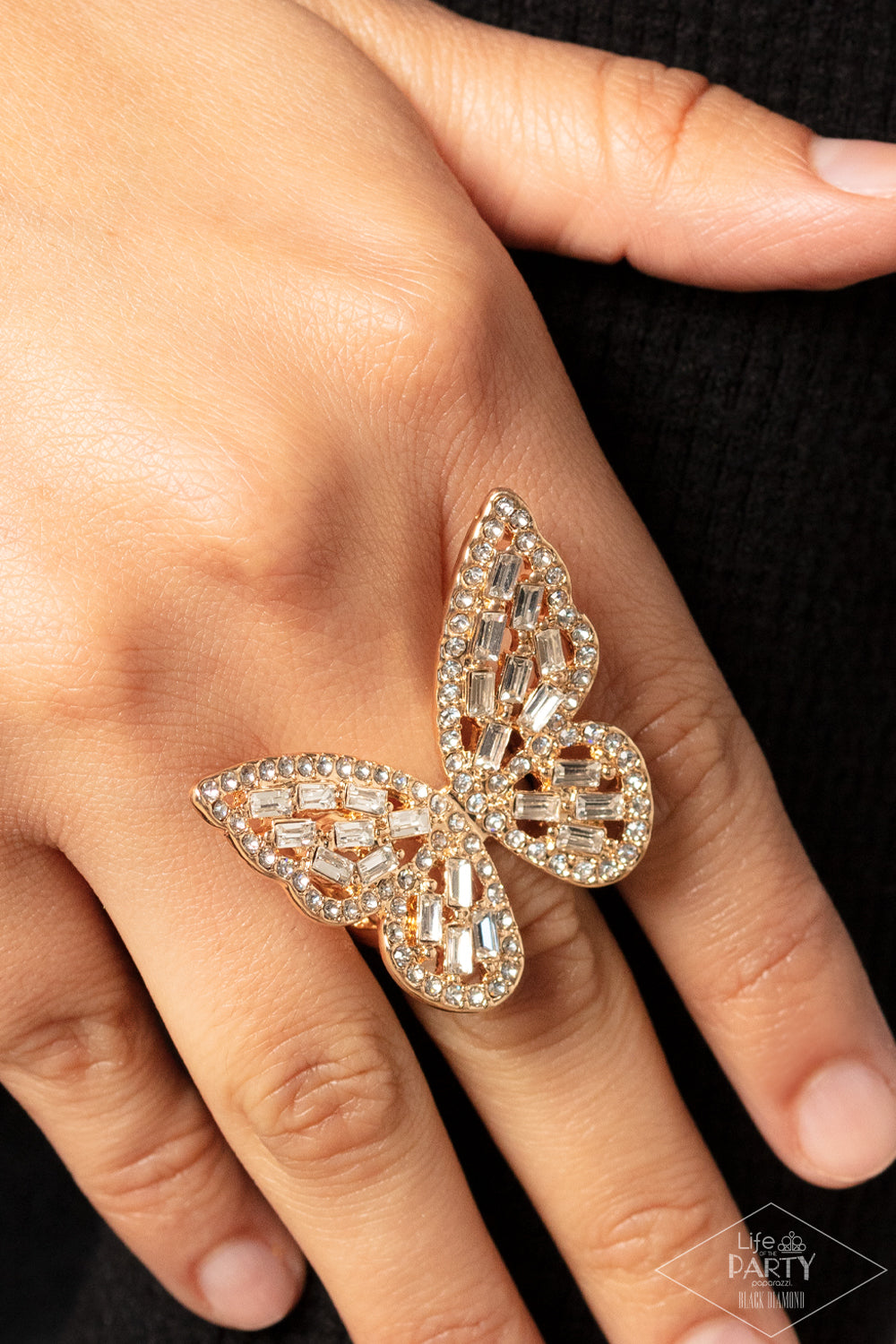 Dainty white emerald cut rhinestones are sprinkled across the golden wings of a butterfly that is encrusted in glassy white rhinestones for a dramatically dazzling finish. Features a stretchy band for a flexible fit.