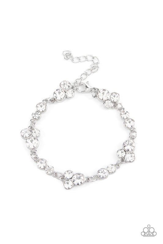Encased in sleek silver frames, dainty pairs and trios of glittery white rhinestones delicately link into a timeless display around the wrist. Features an adjustable clasp closure.
