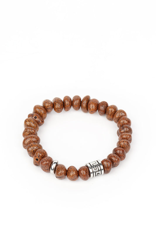 Featuring a natural finish, a collection of faux brown stones are threaded along a stretchy band around the wrist. Shimmery silver accents are added to the earthy compilation for an artisan inspired finish.