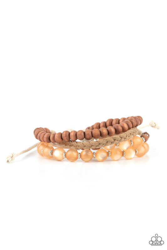 Strands of glassy orange cat's eye beads stand out in an earthy collection of wooden beads and braided twine, giving a polished flair to the natural homespun look as it stacks up the wrist. Features an adjustable sliding knot closure.