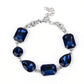 A collection of oversized round, teardrop, and emerald cut blue rhinestones delicately link around the wrist, creating a blinding statement piece. Features an adjustable clasp closure.
