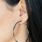 A glistening gunmetal ribbon sharply bends and twists into an oversized hoop for an intense industrial display. Earring attaches to a standard post fitting. Hoop measures approximately 2" in diameter