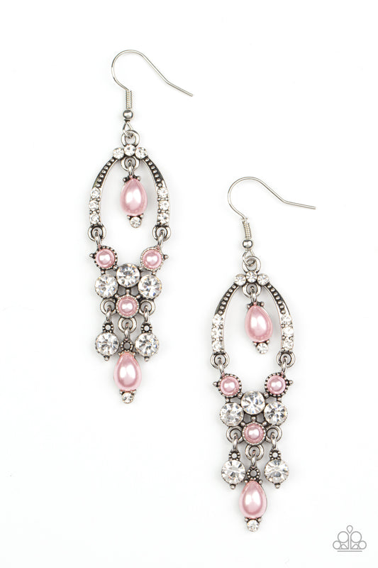 Glittery white rhinestones and pearly pink beaded fittings delicately swing from the bottom of an ornately embellished oval frame. A matching pearly frame dangles from the top of the decorative silver frame, adding timeless movement to the sparkly display. Earring attaches to a standard fishhook fitting.