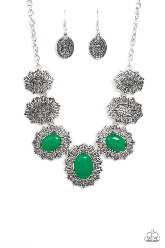 Filled with rustic filigree, scalloped silver frames gradually increase in size as they link below the collar. Three oversized oval green beads adorn the centermost frames, adding an ethereal pop of color to the whimsical display. Features an adjustable clasp closure.