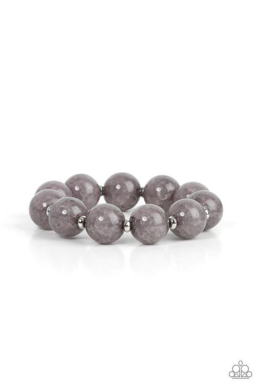 Infused with dainty silver accents, an oversized collection of crackly gray glass-like beads are threaded along stretchy bands around the wrist for an icy look.
