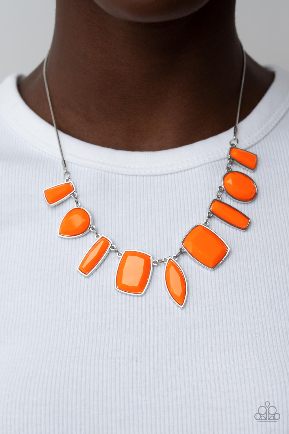 Encased in sleek silver fittings, a faceted assortment of teardrop, marquise, and emerald cut orange beads fan out below the collar for a bold pop of color. Features an adjustable clasp closure.  Sold as one individual necklace. Includes one pair of matching earrings.