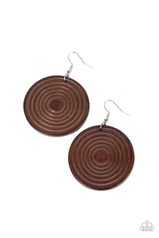 A shiny brown wooden disc is engraved in circular details, resulting in a dizzying pop of color. Earring attaches to a standard fishhook earring.