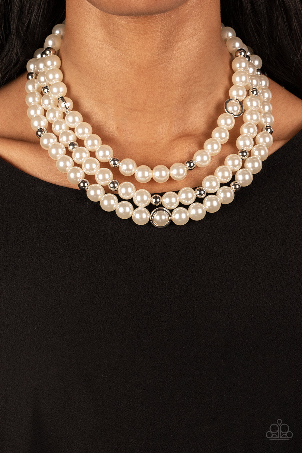Infused with silver beads and silver rings, a bubbly collection of white pearls are threaded along invisible wires that cascade into effervescent layers below the collar. Features an adjustable clasp closure.