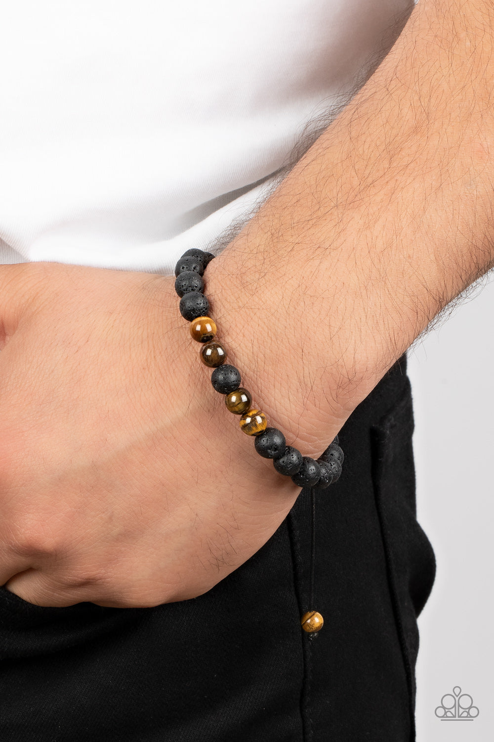 An earthy collection of black lava rock and tiger's eye stone beads are threaded along a black cord around the wrist, resulting in a seasonal pop of color. Features an adjustable sliding knot closure.