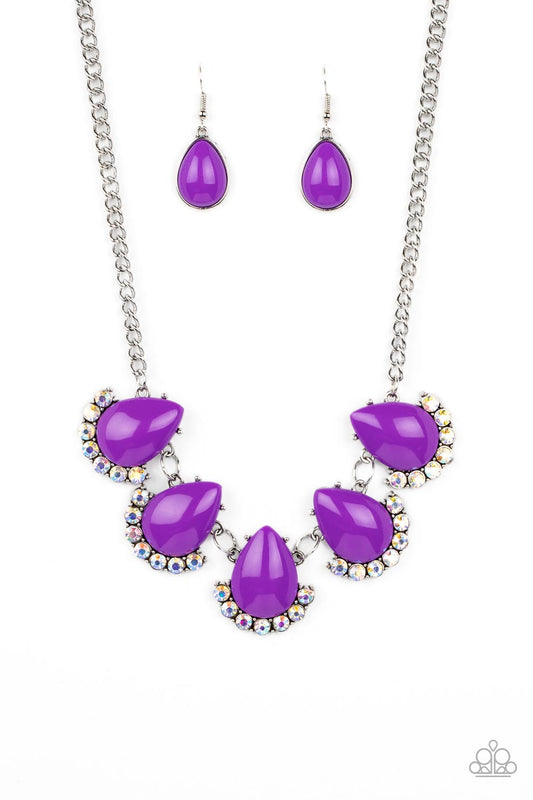 Underscored by rows of iridescent rhinestones, a row of oversized purple teardrop beads dramatically links into a powerful pop of color below the collar. Features an adjustable clasp closure. Due to its prismatic palette, color may vary.  Sold as one individual necklace. Includes one pair of matching earrings.