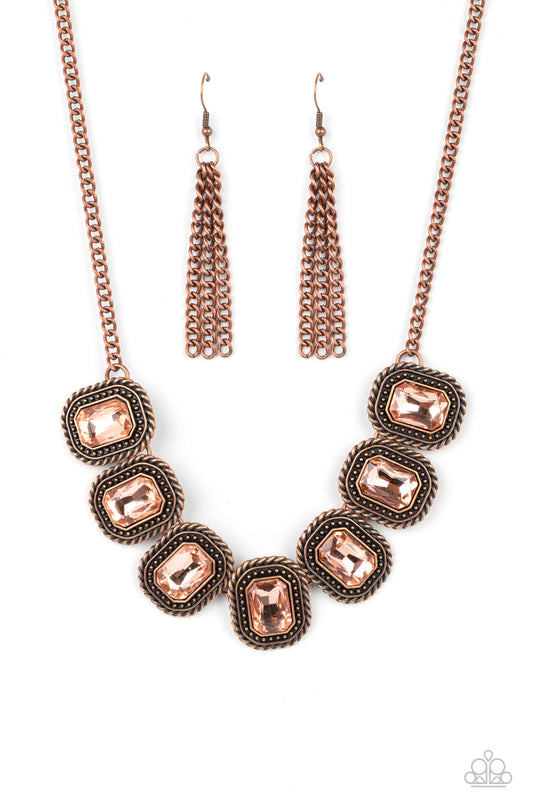 Pressed into rectangular copper frames, radiant-cut rhinestones in a warm, copper undertone smolder below the collar. Each frame is embellished with twisted texture and subtle copper studs, bringing a gritty contrast to the design. Features an adjustable clasp closure.