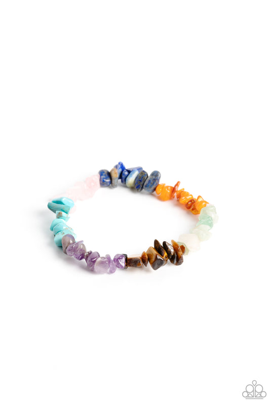 An earthy collection of turquoise, lapis, jade, amethyst, Tiger's eye, orange, gray, and pink pebbles are threaded along a stretchy band around the wrist for a Southwestern finish.