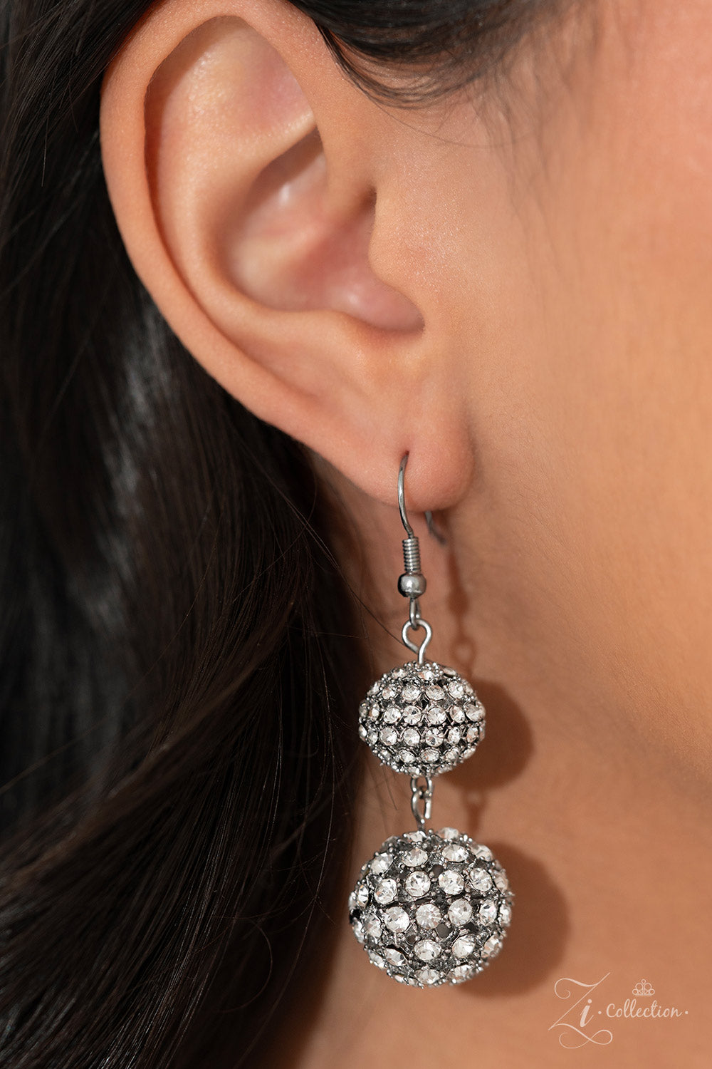Glittery, white rhinestones cluster together, creating dramatically oversized, airy, spheres that sparkle vivaciously. Smaller rhinestone-encrusted spheres dance between the exaggerated accents, resulting in a dynamic display of texture and sheen. Features an adjustable clasp closure.