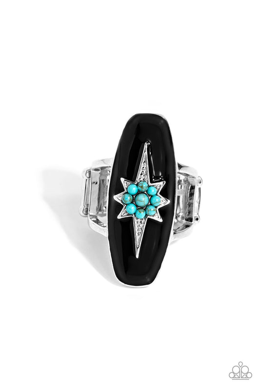 A three-dimensional silver star featuring a turquoise stone flower center is pressed into an elongated black-painted frame atop airy silver bands, creating an earthily stellar centerpiece atop the finger. Features a stretchy band for a flexible fit. As the stone elements in this piece are natural, some color variation is normal.