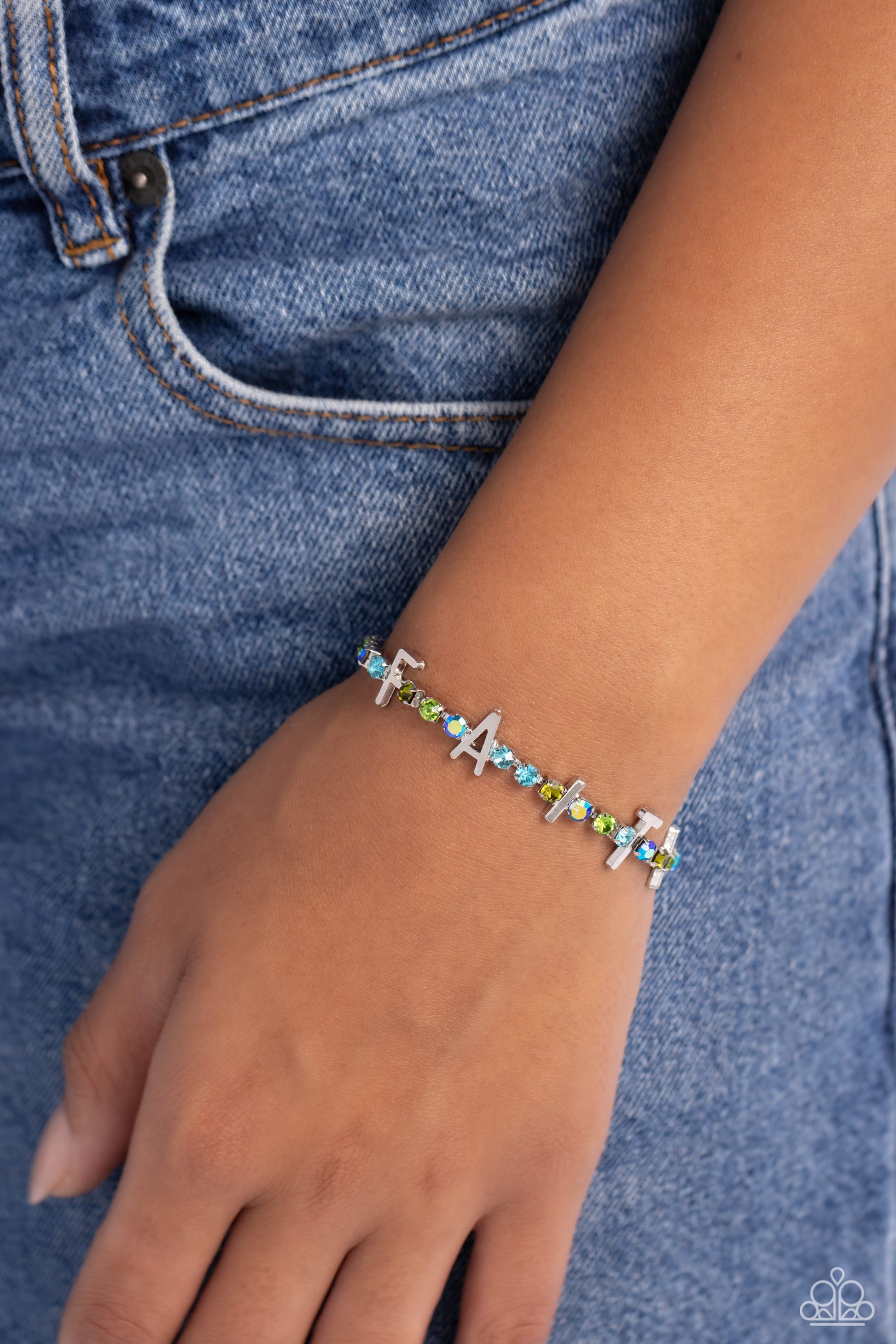 Set in silver square fittings, various multicolored rhinestones gleam around the wrist. Infused along the design, sleek silver letters spell out the word "FAITH" for an inspirational finish. Features an adjustable clasp closure. Due to its prismatic palette, color may vary.