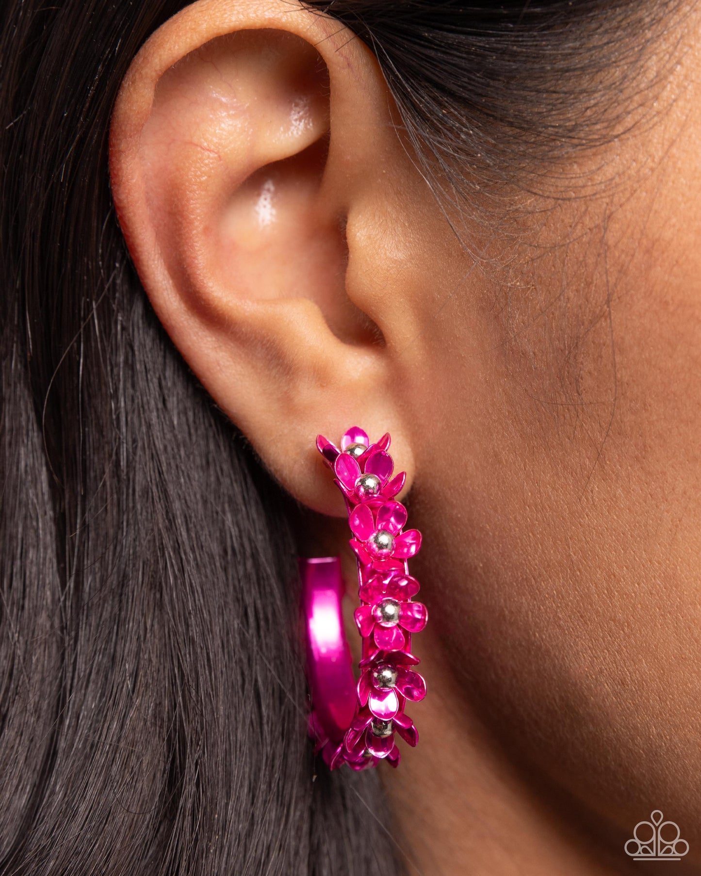 Dipped in a hot pink hue, a hollowed-out hoop curls around the ear. Featuring silver beaded centers, metallic hot pink flowers bloom along the curl of the hollow of the hoop for a fashionable display. Earring attaches to a standard post fitting. Hoop measures approximately 1 1/4" in diameter.